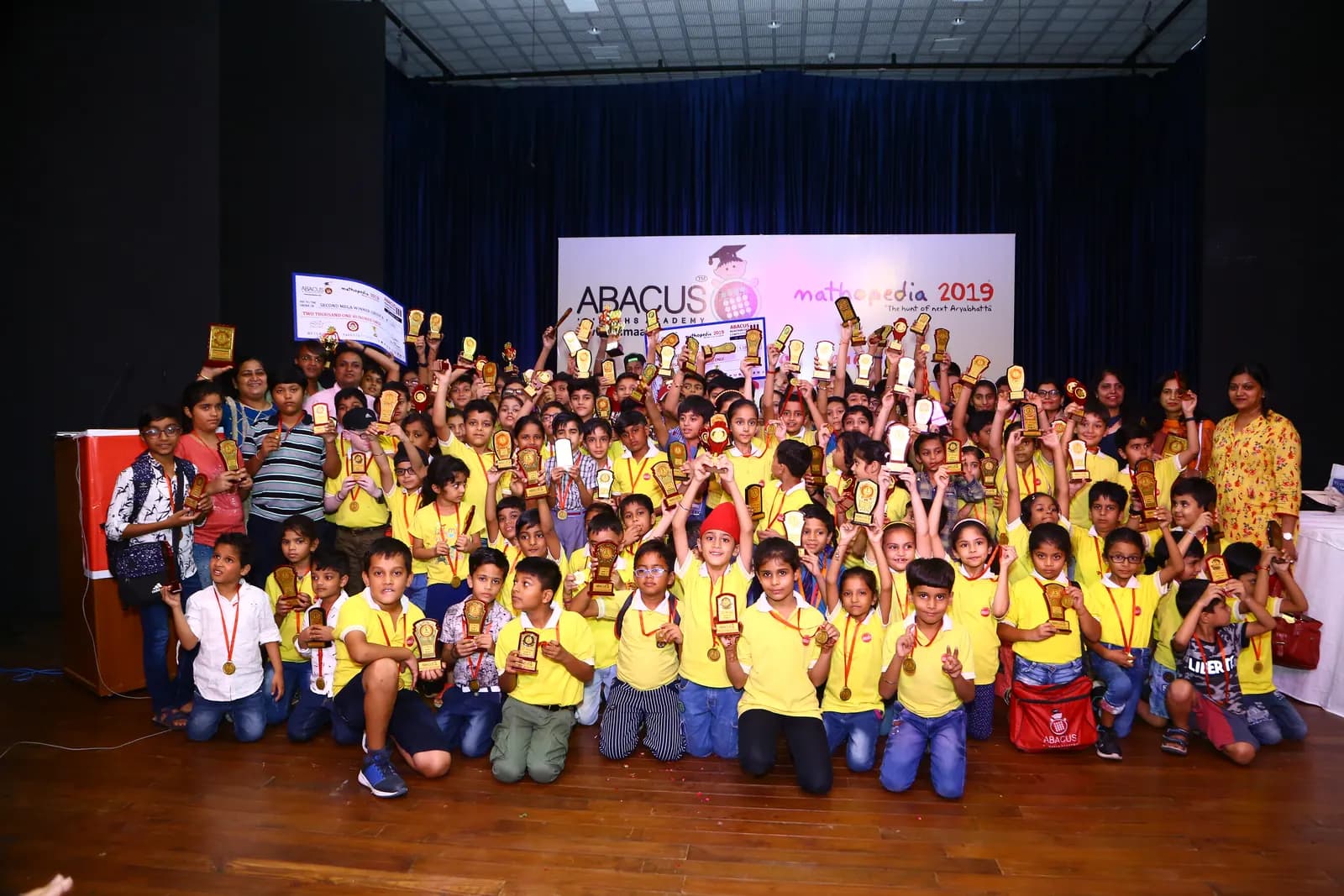 Students and teachers celebrating with trophies at academy award function