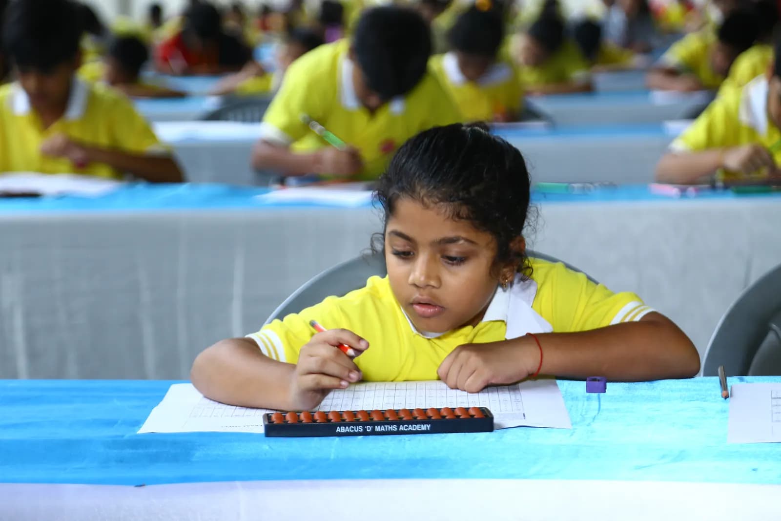 Academy student participating in Mathopedia competition examination with abacus